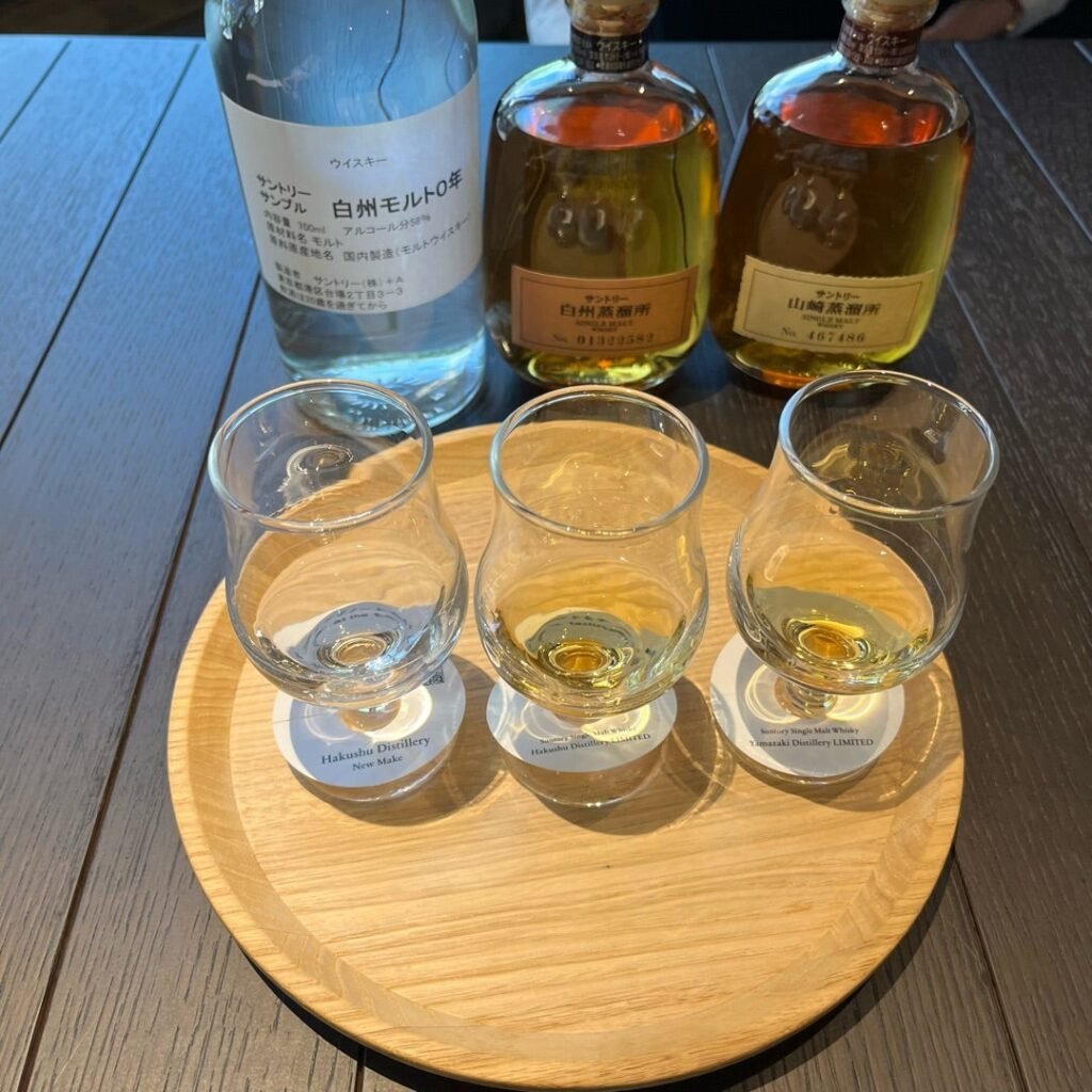 Yamazaki and Hakushu whisky tasting flight with three single malt glasses at the Suntory distillery tasting counter