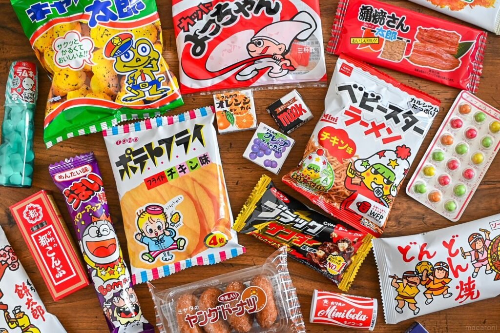 Assortment of Japanese snacks you might find in a japanese snack subscription box, including Umaibou, Baby Star ramen chips, and Black Thunder chocolate bar