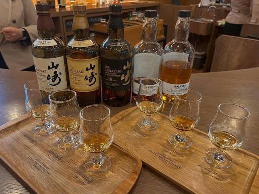 Yamazaki whisky bottles and tasting glasses lined up during a Suntory distillery tour